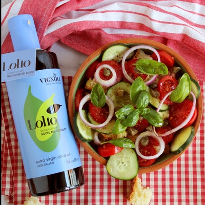 Vignoli Nocellara del Belice Monocultivar Extra Virgin Olive Oil front of 16.9oz bottle with bowl of salad beside