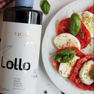 Vignoli Lollo Organic Extra Virgin Olive Oil front of 16.9oz bottle with Caprese salad 