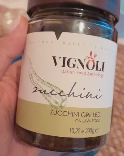 Vignoli Grilled Zucchini in Olive Oil front of 10.22oz jar being opened and removed with fork onto plate