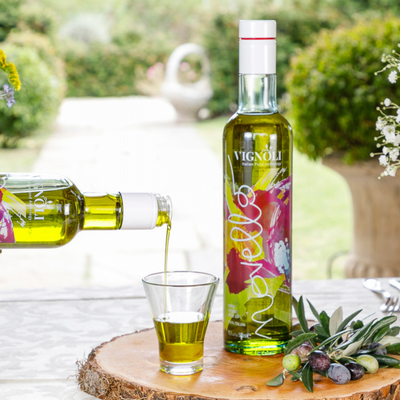 Vignoli Novello Extra Virgin Olive Oil front of 16.9oz bottle being poured into tasting glass