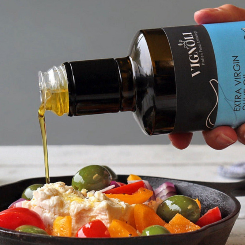Black Garlic Infused Extra Virgin Olive Oil front of 8.5oz bottle pouring over salad