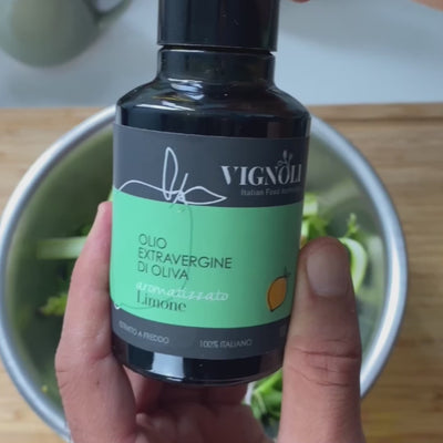 Vignoli Lemon Infused Extra Virgin Olive Oil front of 8.5oz bottle pouring over salad