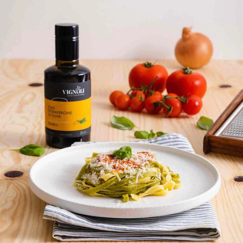 Basil Infused Extra Virgin Olive Oil front of 8.5oz bottle with pasta on table